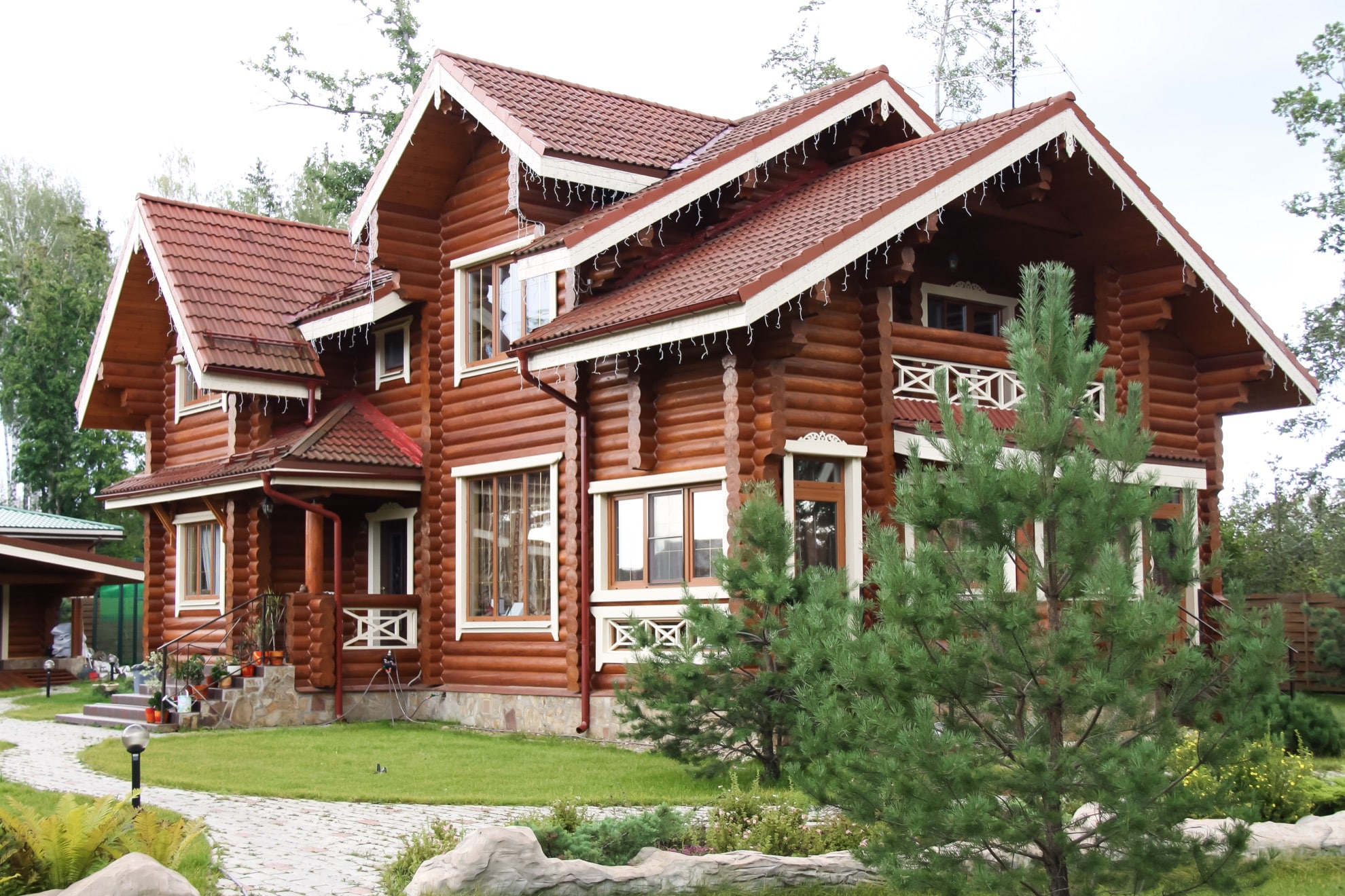 Фасад двухэтажного деревянного дома из оцилиндрованного бревна - лиственница 260мм